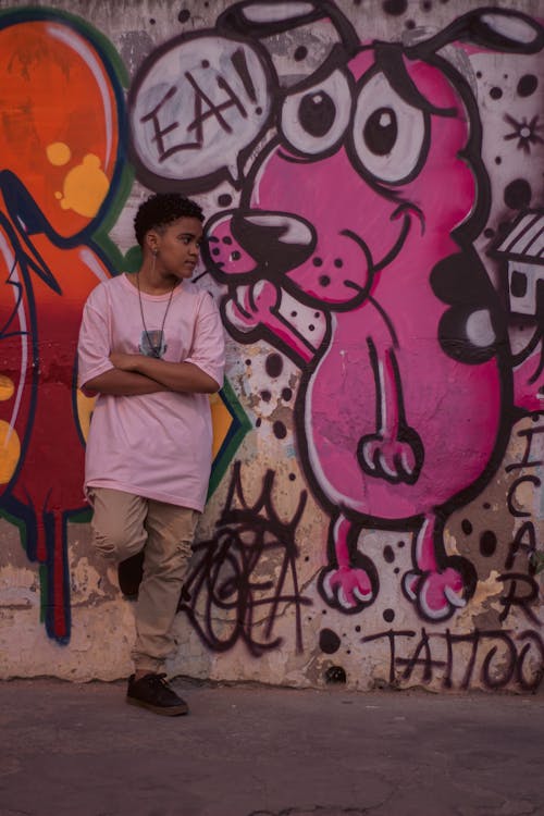 Boy Leaning against a Wall with Pink Graffiti