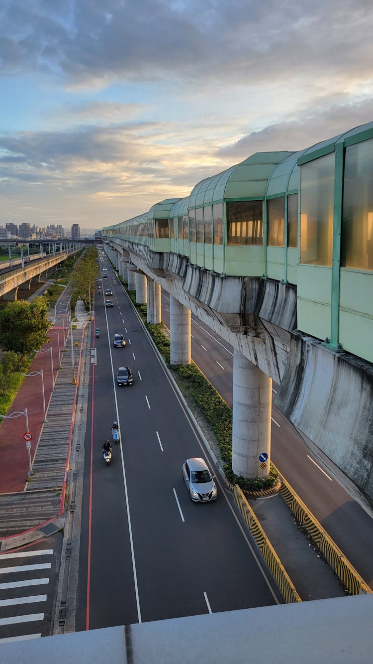 A Monorail Over Cars On An Asphalt Road