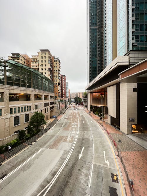 Gray Concrete Road Between Buildings