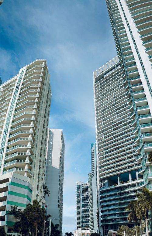 Free Upward view of tall modern skyscrapers under a clear blue sky, showcasing urban architecture. Stock Photo