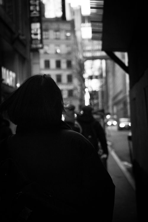 Free Black and white photo of silhouettes walking along a bustling city street. Stock Photo