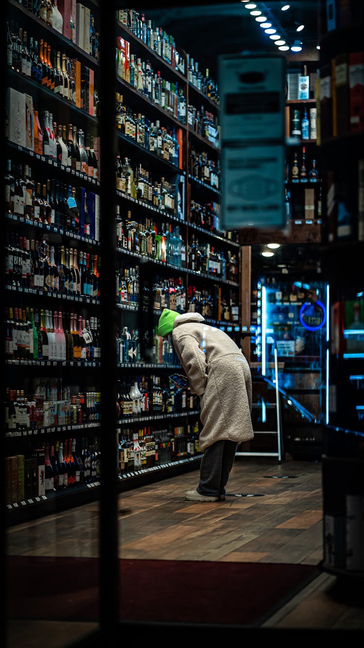 Woman Looking At The Bottle With Alcohol