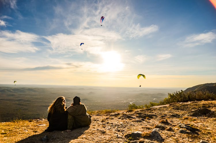 Couple Looking At Para Gliders In Sky