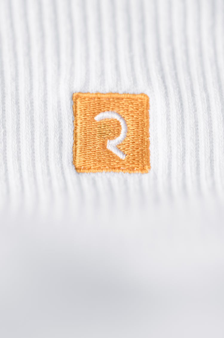 Orange Embroidery On A White Textile