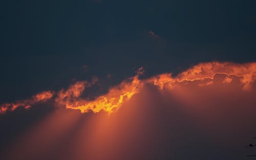 Free Sunlight Behind Clouds Under a Dark Blue Sky Stock Photo