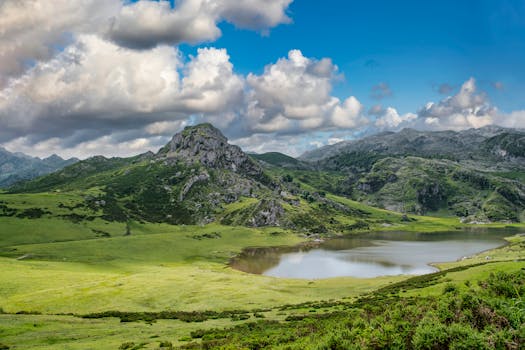Breathtaking mountain landscape with lush greenery, serene lake, and blue skies.