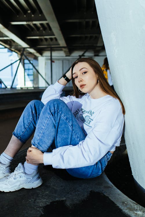 Stylish Young Woman in Denim Pants and White Sweaters 