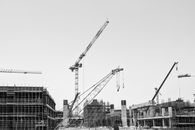 Grayscale Photo of Crane Near Buildings
