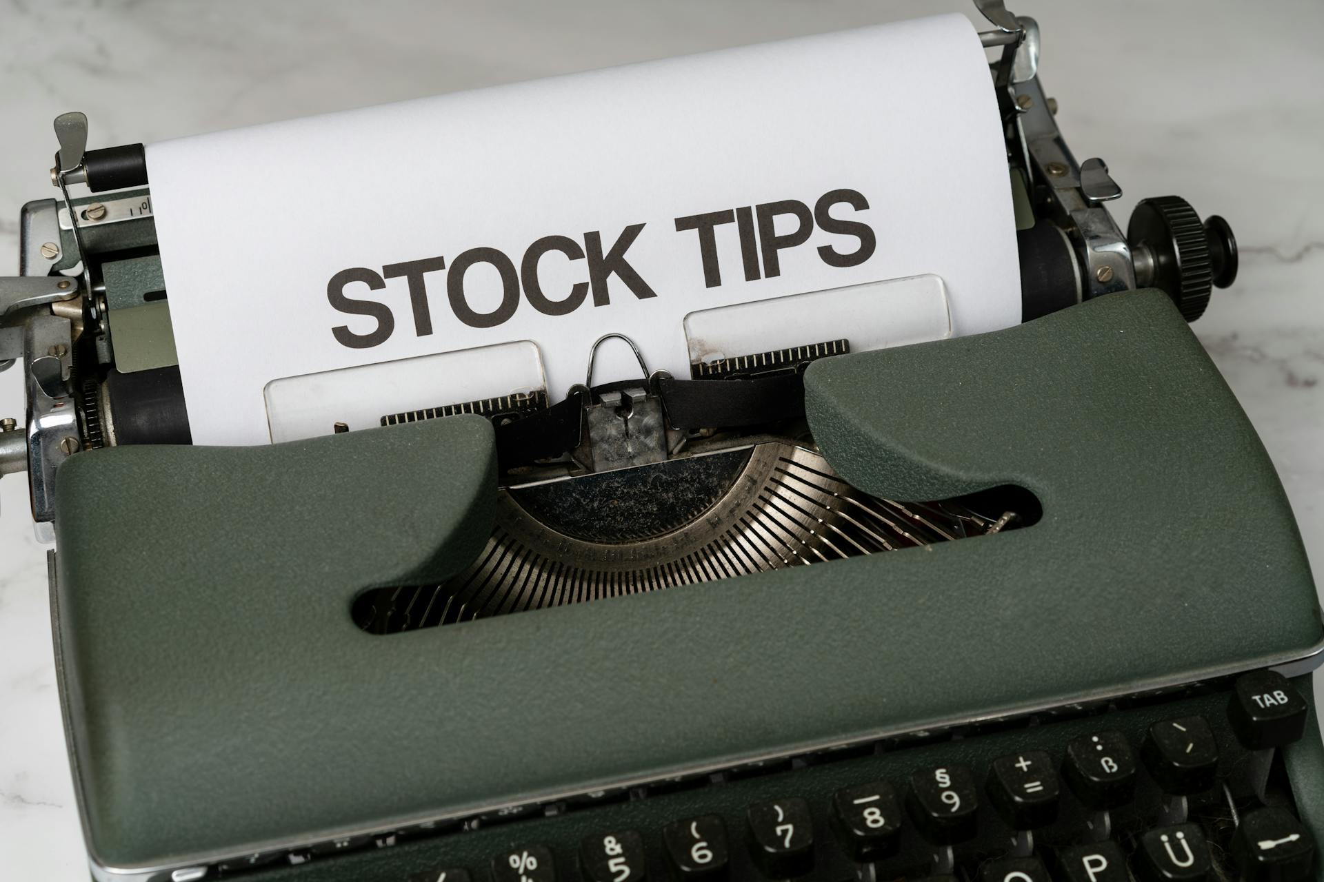 Old-fashioned typewriter displaying stock market tips, symbolizing retro finance advice.