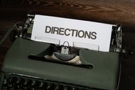 Green and White Typewriter on Brown Wooden Table
