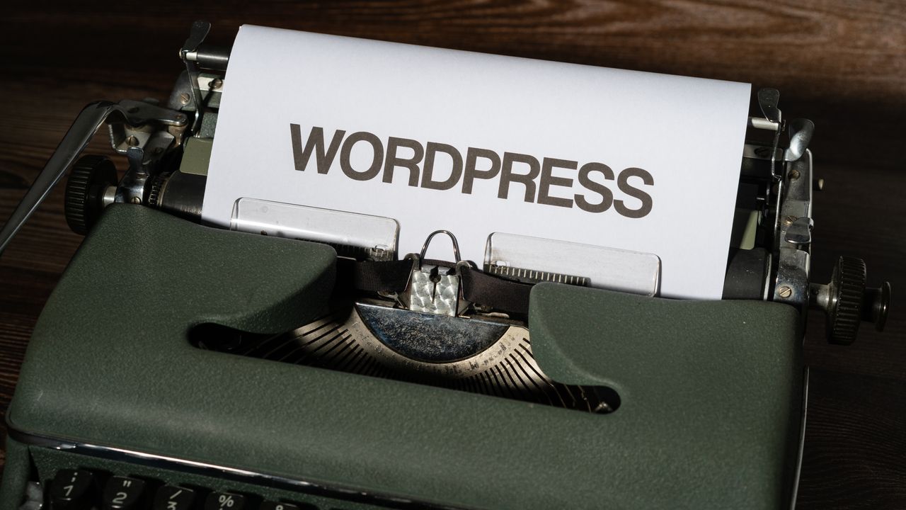Close-up of a vintage typewriter with 'WordPress' typed on white paper.
