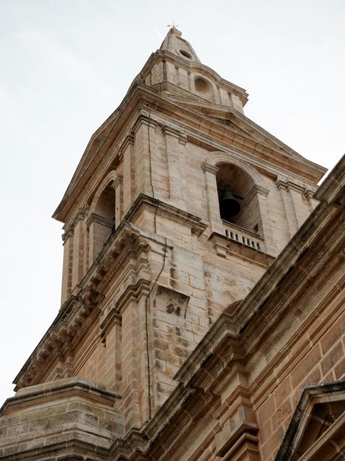 Free A stunning low-angle view of a historic brick church tower in Malta, showcasing intricate architecture. Stock Photo