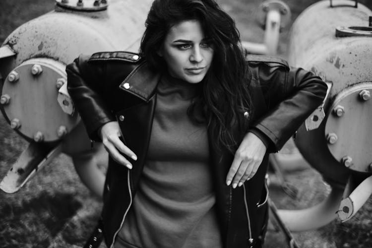 A Beautiful Woman Leaning On Metal Tanks