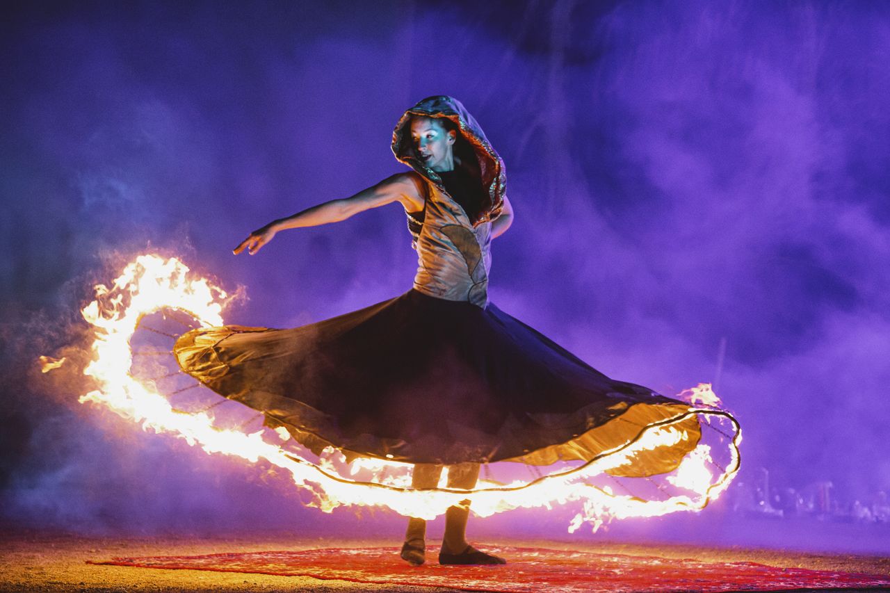 mesmerizing fire dancer twirling flames in a captivating night perform