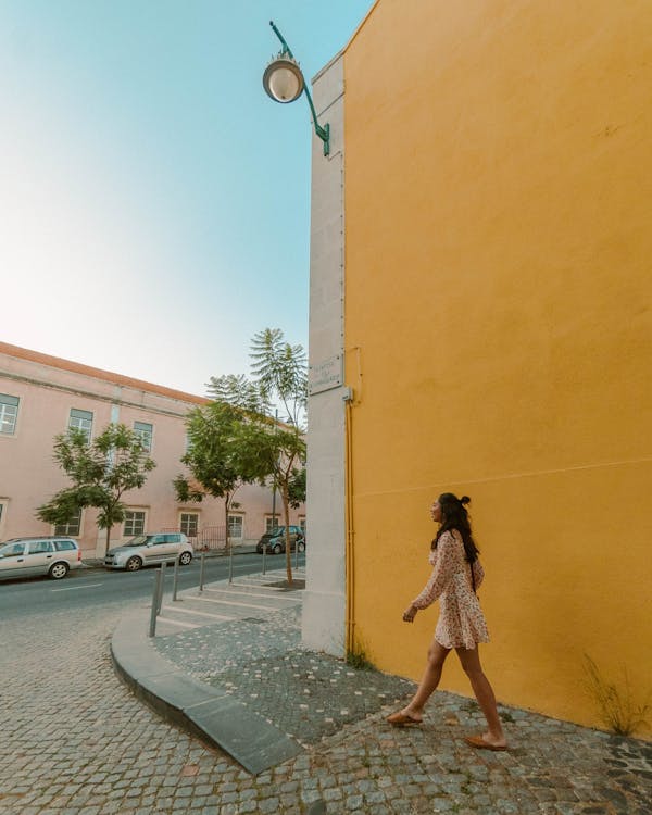 Free Woman Wearing a Short Dress Walking on a Sidewalk Stock Photo