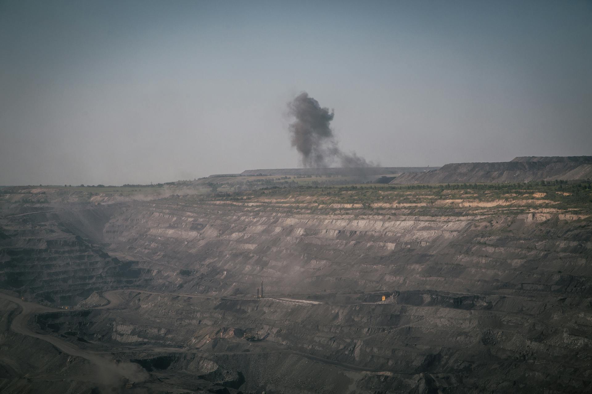 Aerial shot of the smoky quarry in Novokuznetsk, Russia, showing industrial mining activity.