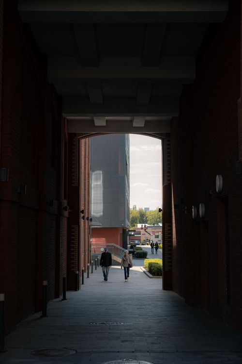 Free Two individuals walking through a tunnel in Moscow's modern urban landscape. Stock Photo