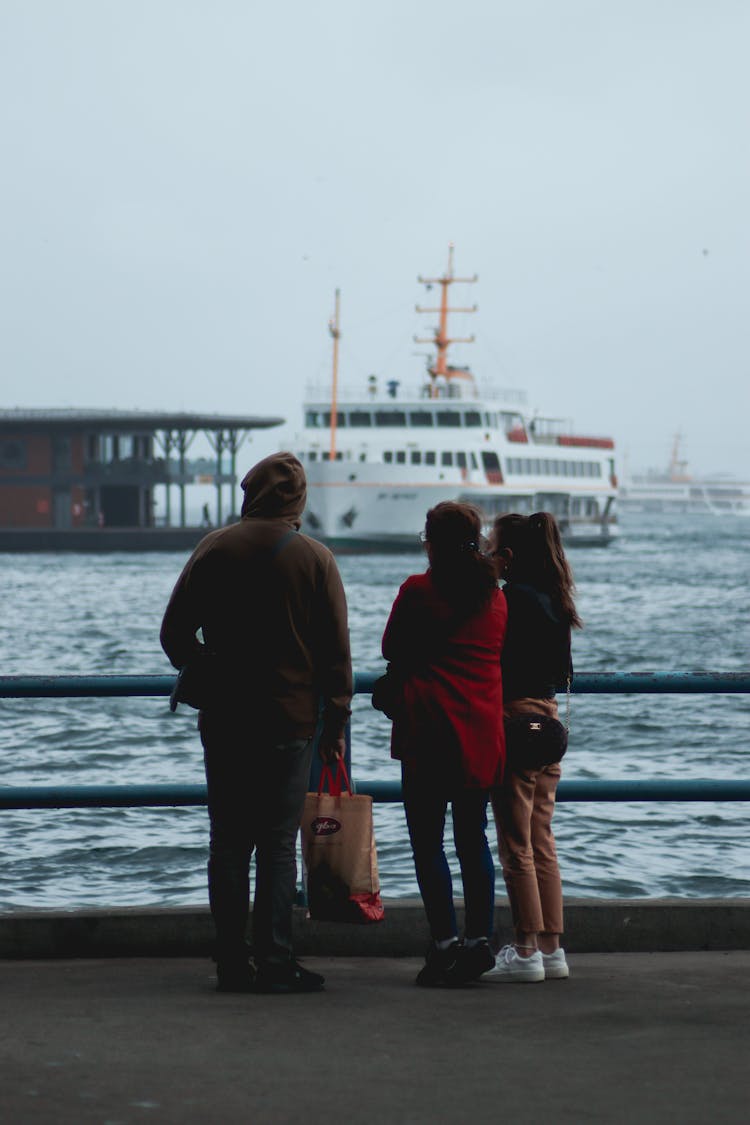 Backview Of Family Hanging Out On A Riverside 