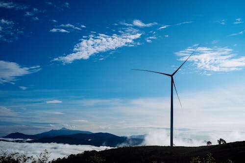 A Wind Turbine on Mountain Under Blue Sky 