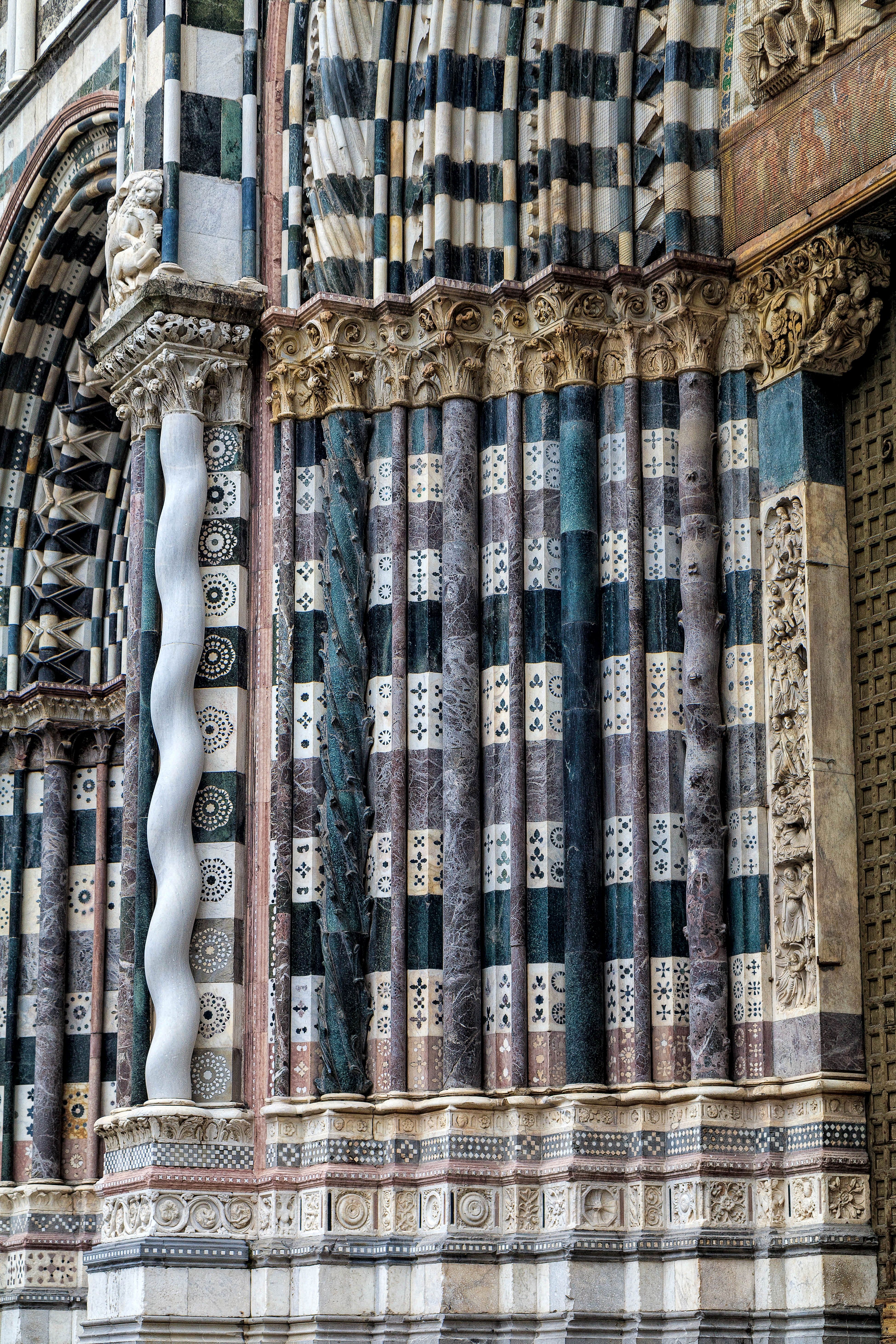 Detailed view of the ornate facade of San Lorenzo Cathedral in Genoa, showcasing intricate architectural patterns.