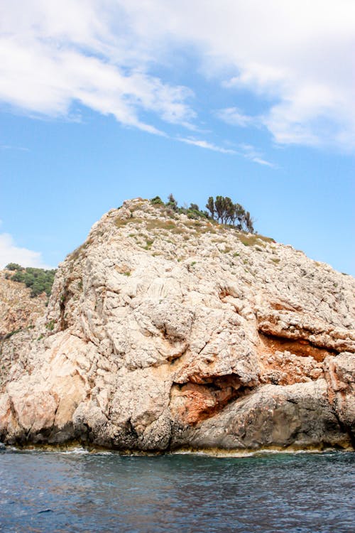 Brown Rock Formation Under Blue Sky and White Clouds