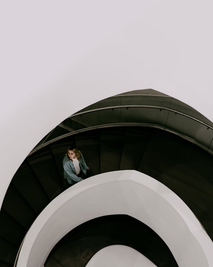 A Woman Going Up A Spiral Staircase