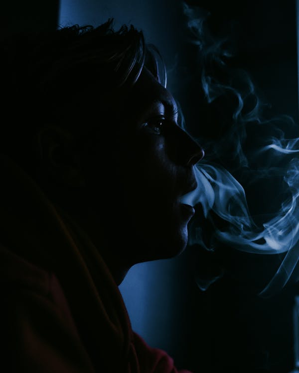 Close Up of Woman Smoking in Dark Room · Free Stock Photo