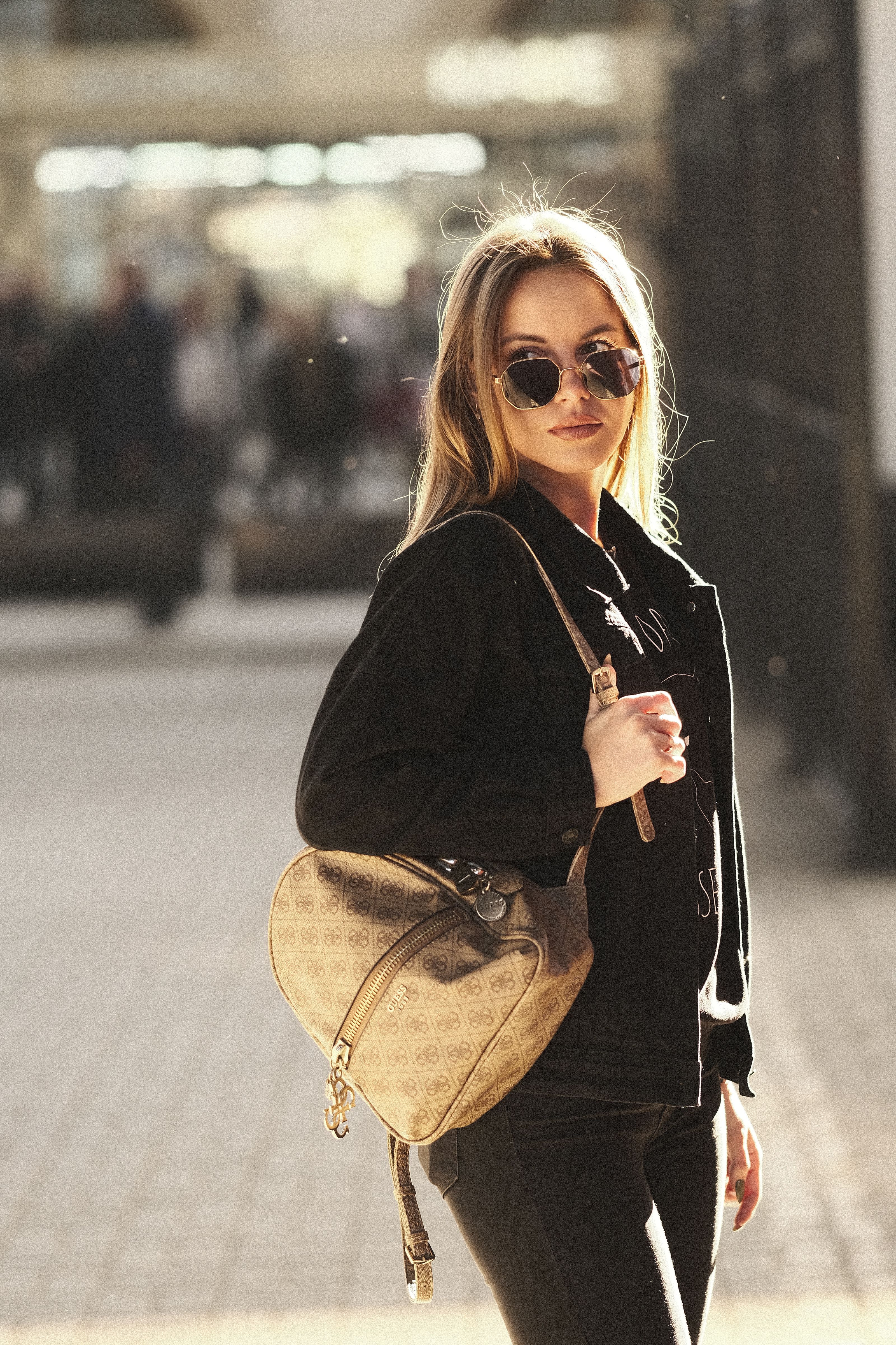 Mulher fashionista com uma bolsa e óculos de sol em um dia ensolarado em Moscovo.
