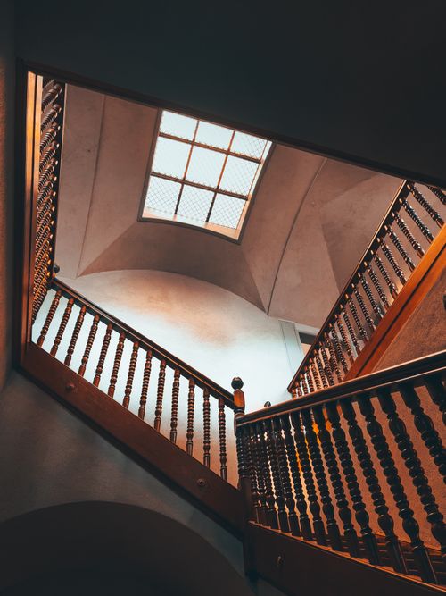 Free Low angle view of a wooden staircase with ornate handrails in a Zürich building. Stock Photo