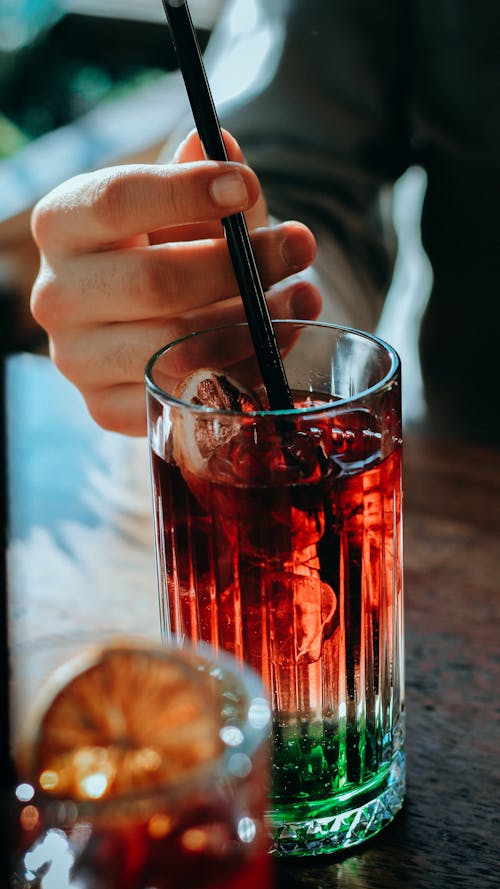 Free Person Stirring a Drink with a Straw Stock Photo