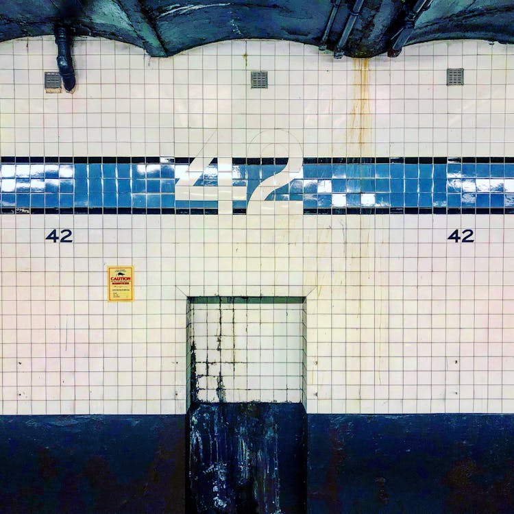 A White And Blue Tiled Wall With Number