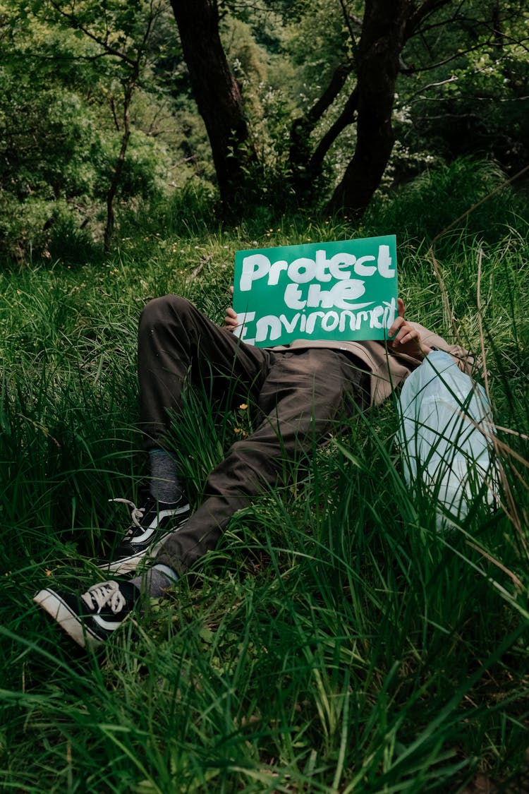 Person Lying Down On Grass With Banner