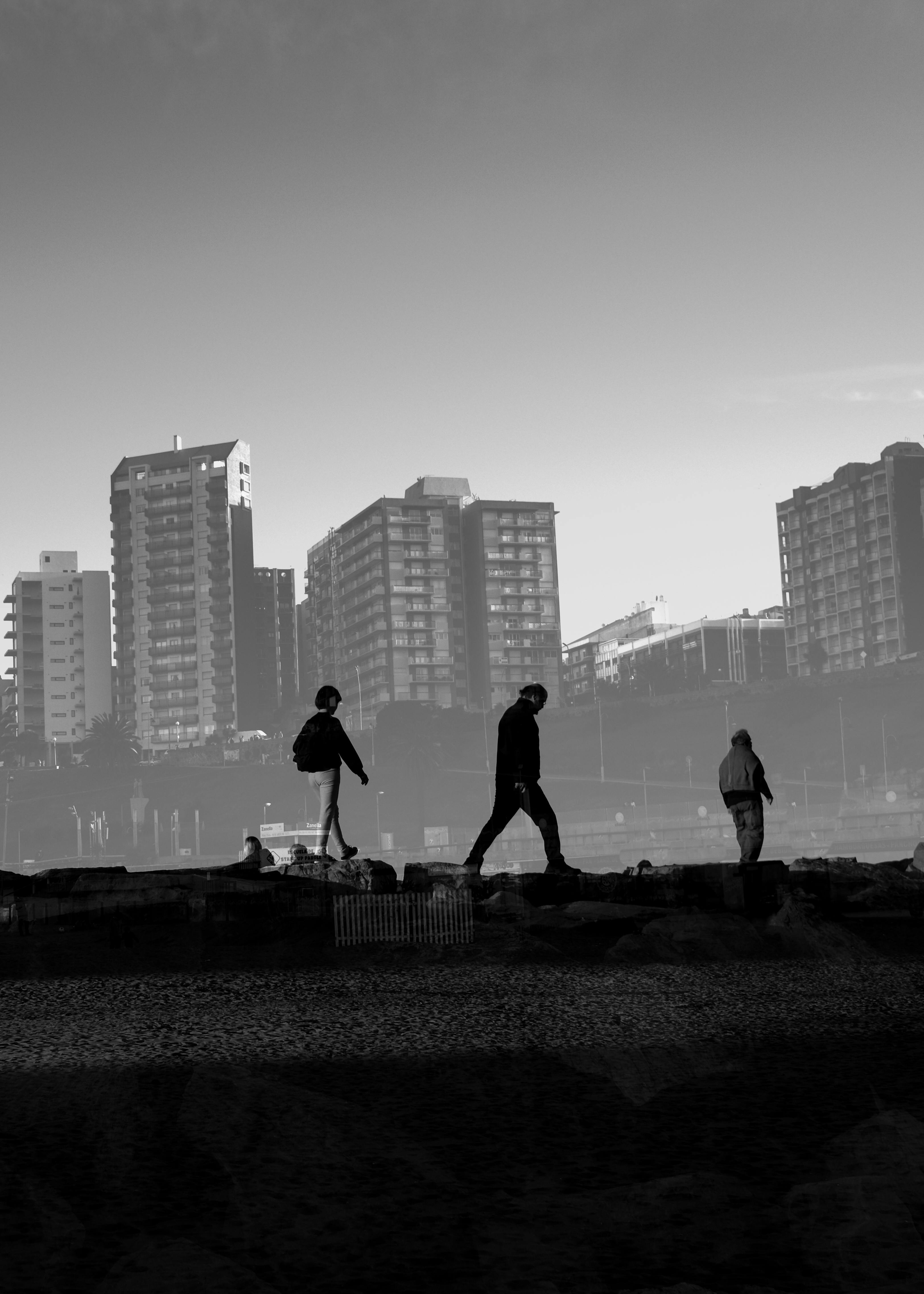 Black and white cityscape with silhouettes walking along the seafront in Mar del Plata, Argentina.