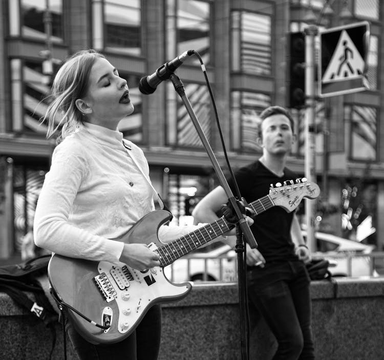 Woman Singing And Playing An Electric Guitar On The Street