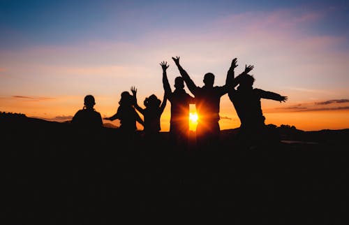 Free Silhouette Of People Raising Hands During Golden Hour Stock Photo
