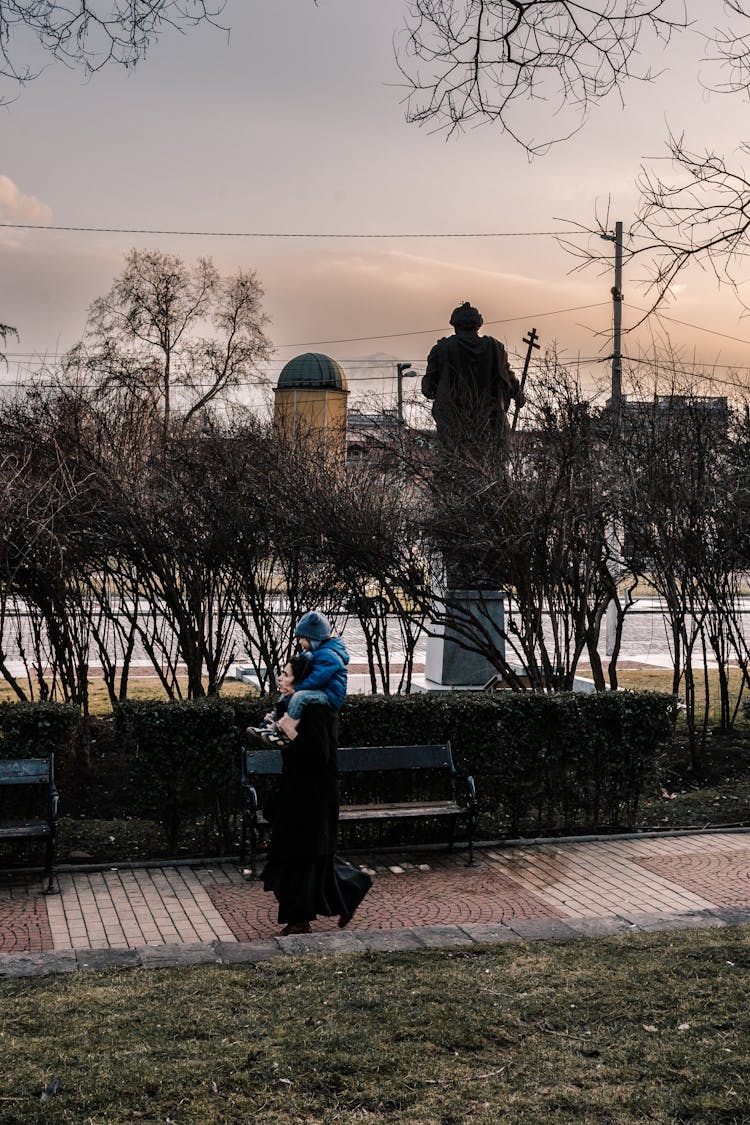 Mother And Child Walking On A Park 