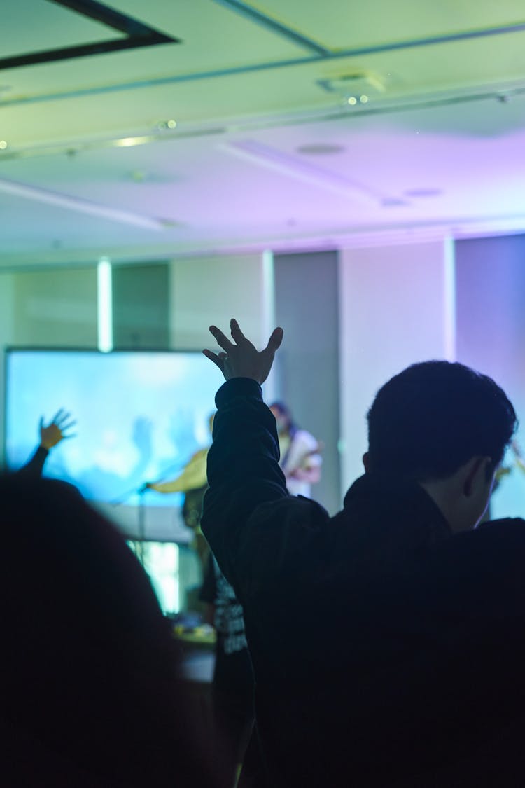 A Person In Black Jacket Raising His Hands