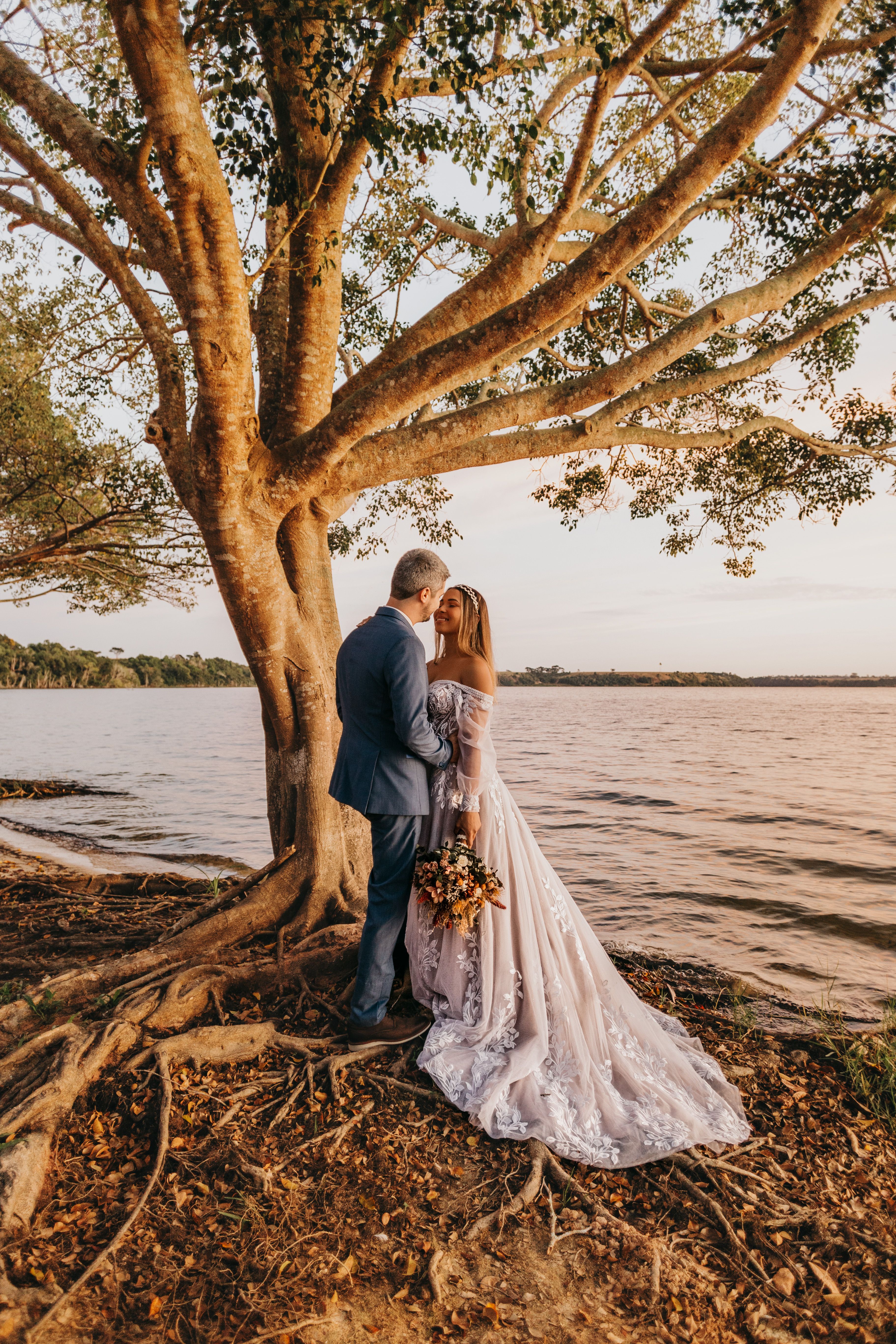 A Bride and Groom Standing Together Near the Tree · Free Stock Photo