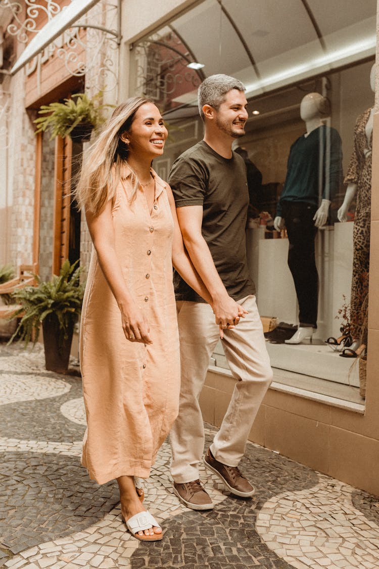 Happy Couple Walking In City And Holding Hands