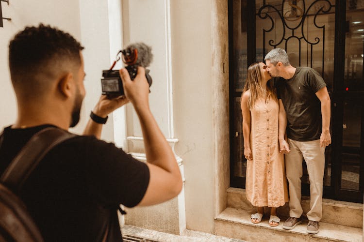 Photographer Taking Picture Of Couple Kissing