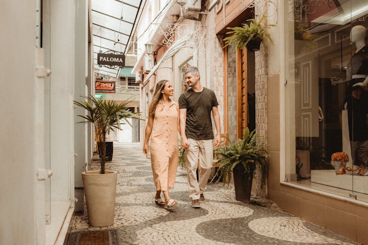 Couple Holding Hands While Walking In A Shopping District