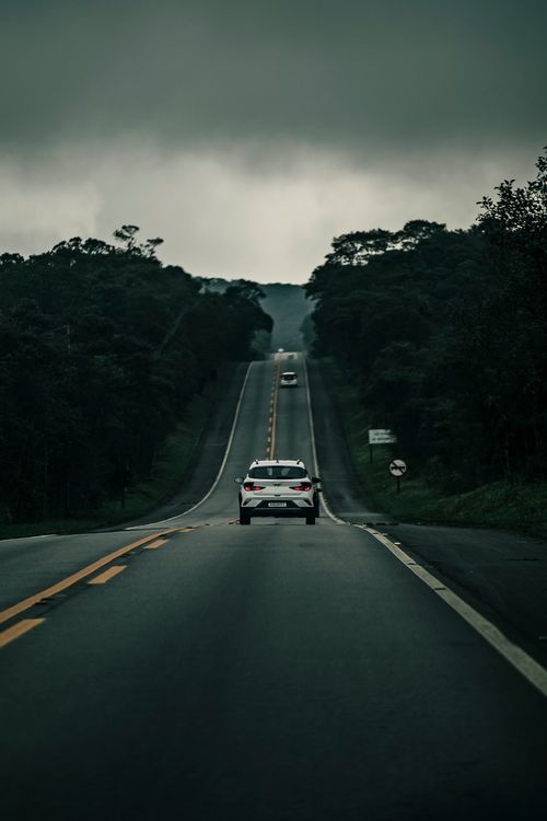 Free Cars driving along a moody highway in São Paulo, Brazil, showcasing a dramatic sky. Stock Photo