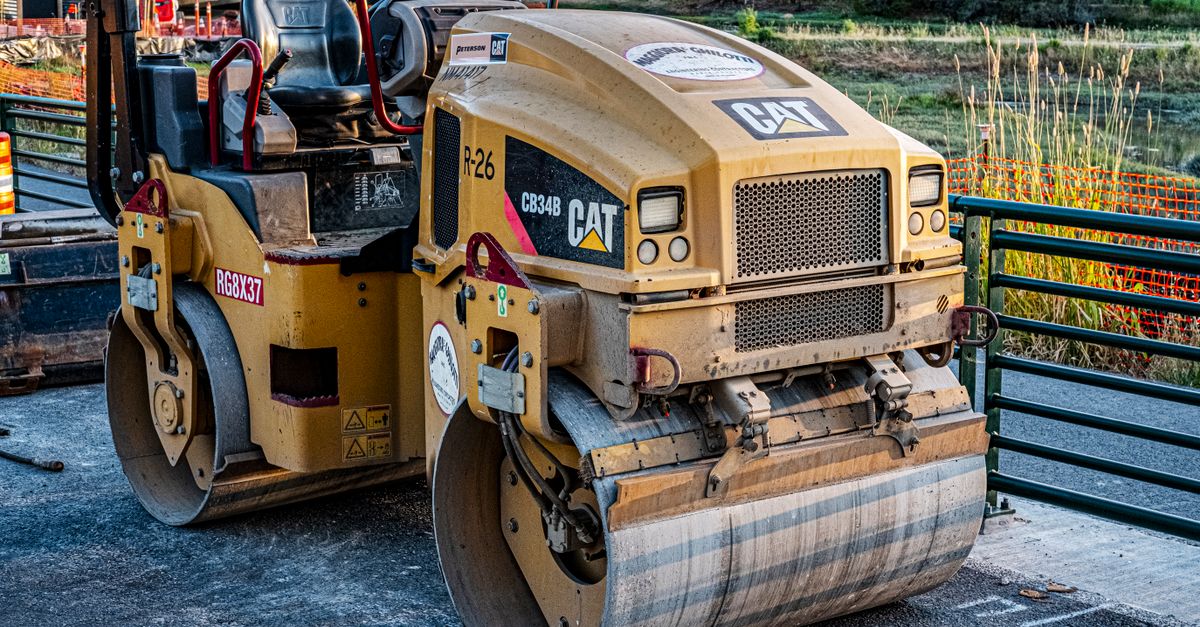 A CAT road roller on an outdoor construction site, perfect for industrial imagery.