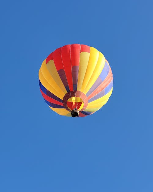 Multicolored Hot Air Balloon in Mid Air Under Blue Sky