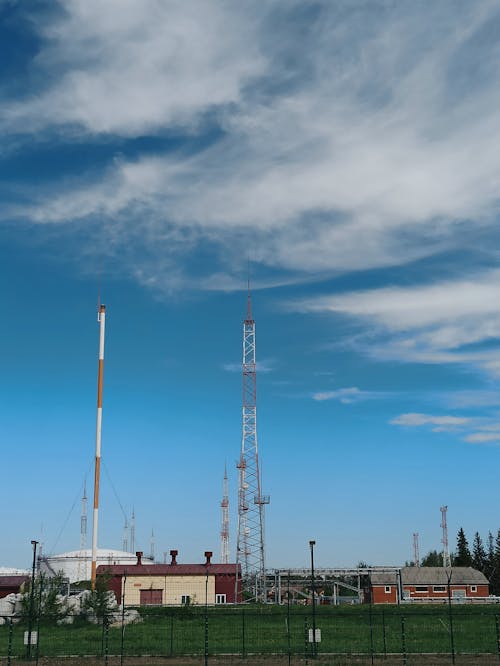 Gratis stockfoto met bewolkte lucht, gebouwen, hek