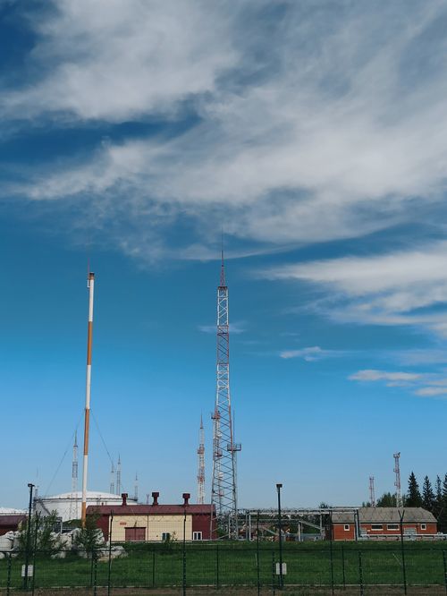 Free Vertical shot of communication towers under a cloudy sky in Berdsk, Russia. Stock Photo