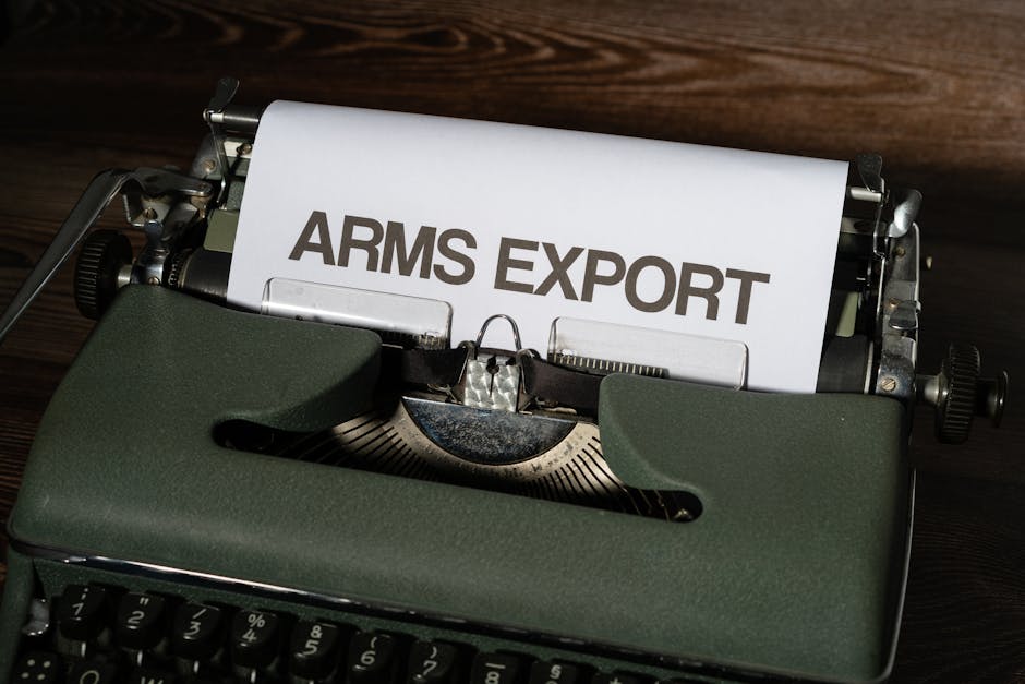 Close-up of a vintage typewriter with paper showing the text 'ARMS EXPORT'.