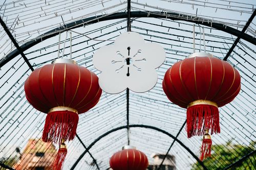 Free Red Chinese lanterns hang in a decorative outdoor setting, symbolizing cultural festivity. Stock Photo