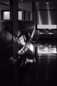 Stylish grayscale hallway with chairs casting shadows, ideal for design and architecture themes.