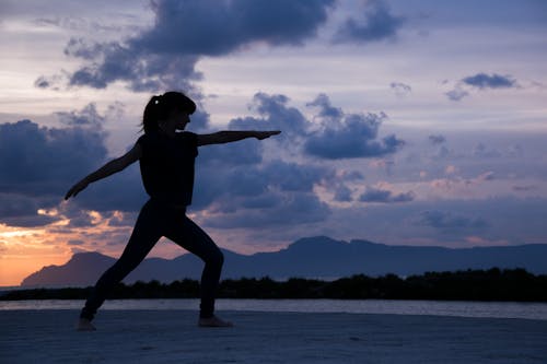 Free Silhouette of a Woman Doing Yoga Stock Photo